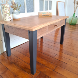 Table basse piètement noir fusain prise de profil, illustrant ses dimensions compactes et son style élégant.