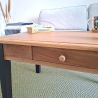 Détail du plateau en bois de la table basse et du tiroir, finition vernis mat, mettant en valeur les nuances naturelles du bois.