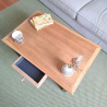 Vue de la table basse avec son tiroir discret entrouvert, idéal pour le rangement des petits objets du quotidien.