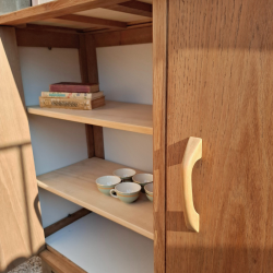 Détail de l'intérieur du meuble : vue sur les étagères en pins et sur l'une des portes