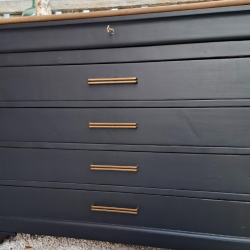 Commode relooké en noir Queue de Pie.  Vue sur les détails des 5 tiroirs et des poignées droites cuivrées