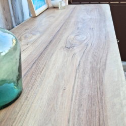 Vue en détail du plateau en noyer conservé en bois brut et vernis. Détails des jolies veines du bois.